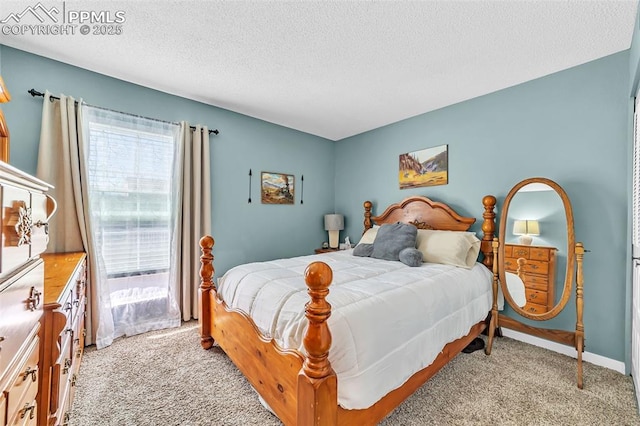 bedroom featuring light carpet, a textured ceiling, and baseboards