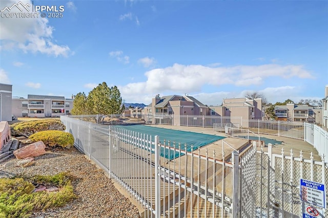 view of pool featuring fence and a residential view