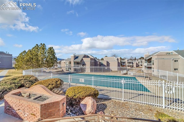 pool featuring a patio area, fence, and a residential view