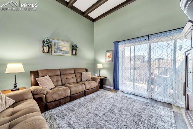 living area featuring baseboards, high vaulted ceiling, wood finished floors, and beamed ceiling