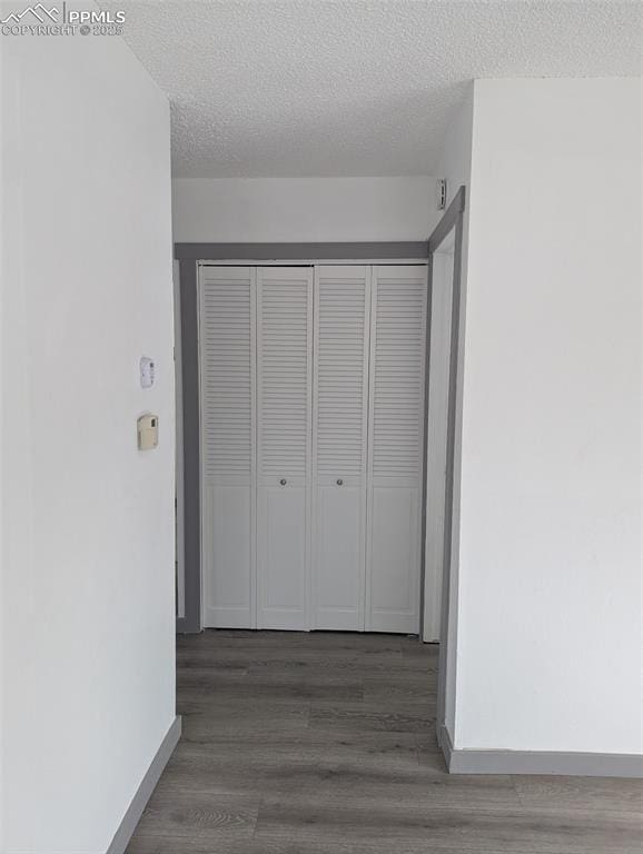 4211 Hunts Mill Ter, Colorado Springs, CO 80910 - hall with baseboards, a textured ceiling, and wood finished floors