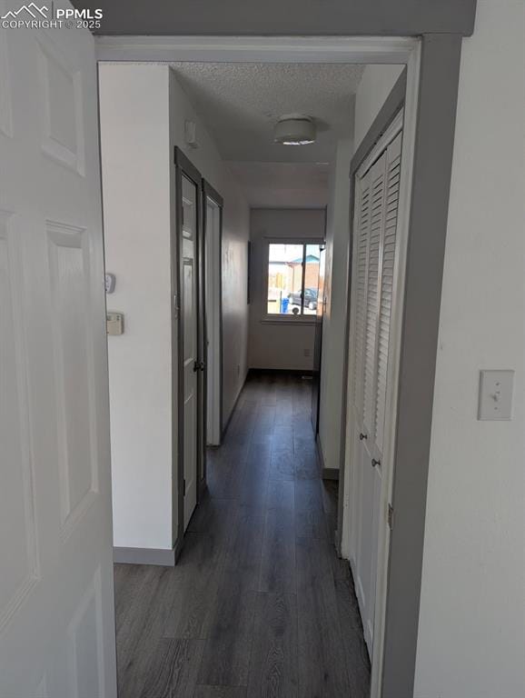 4211 Hunts Mill Ter, Colorado Springs, CO 80910 - corridor with baseboards, dark wood-style flooring, and a textured ceiling