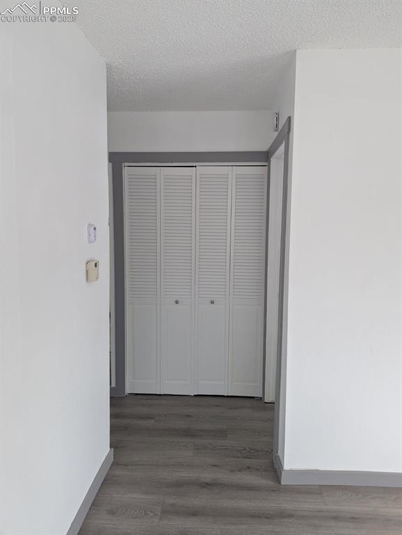 4211 Hunts Mill Ter, Colorado Springs, CO 80910 - corridor with baseboards, a textured ceiling, and wood finished floors