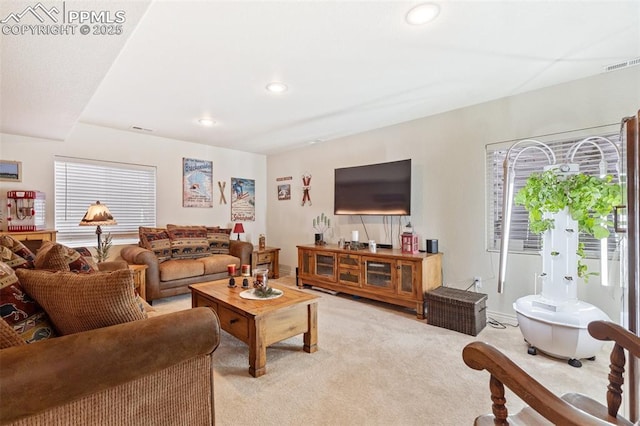 living room with recessed lighting, visible vents, and light colored carpet