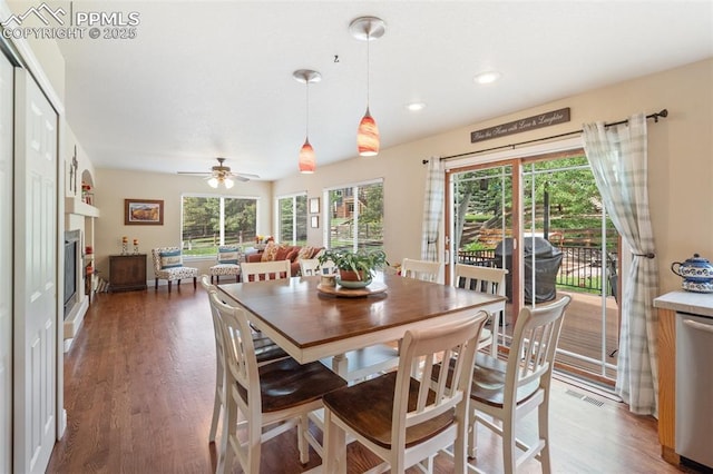 dining room with ceiling fan, recessed lighting, visible vents, light wood-type flooring, and a glass covered fireplace