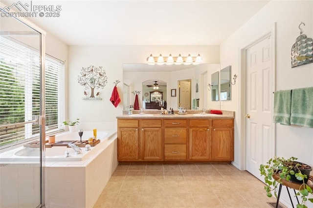 bathroom featuring tile patterned floors, a sink, a bath, and double vanity