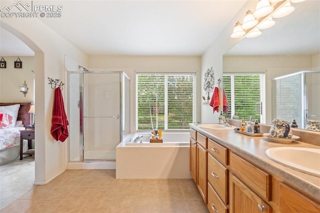 ensuite bathroom featuring double vanity, a stall shower, a sink, tile patterned flooring, and a bath