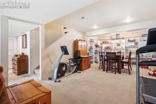 interior space with baseboards, visible vents, and light colored carpet