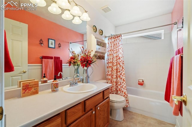 bathroom featuring toilet, shower / tub combo, vanity, visible vents, and wainscoting