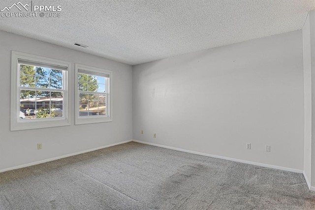 carpeted empty room featuring a textured ceiling, visible vents, and baseboards