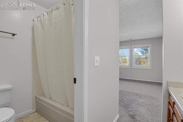 bathroom featuring shower / bathtub combination with curtain, toilet, a textured ceiling, vanity, and baseboards