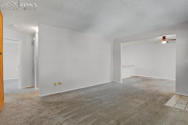 carpeted empty room featuring a textured ceiling, baseboards, and a ceiling fan