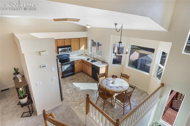 kitchen with light countertops, vaulted ceiling, a sink, a chandelier, and black appliances