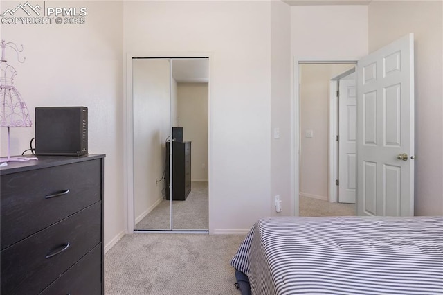 bedroom featuring light carpet, baseboards, and a closet