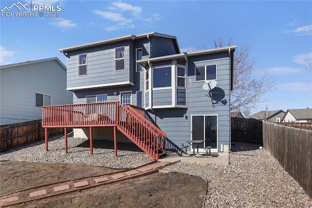 rear view of house with a patio area, a fenced backyard, stairs, and a deck