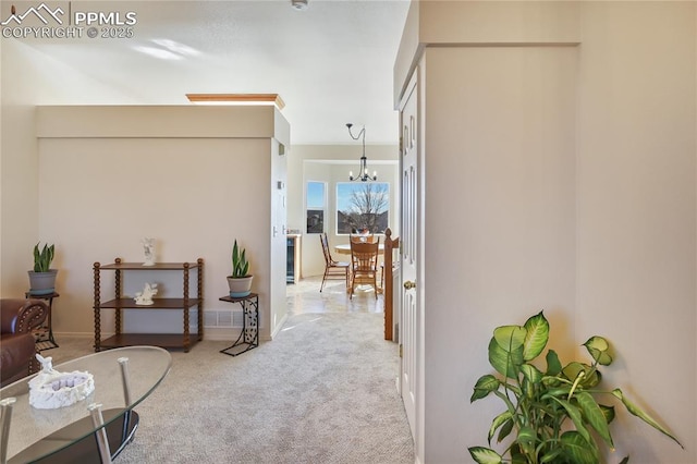 interior space featuring baseboards, carpet flooring, and an inviting chandelier