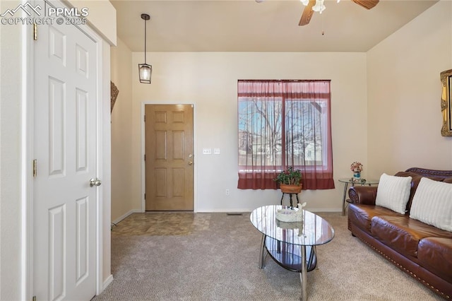 carpeted living room featuring ceiling fan and baseboards