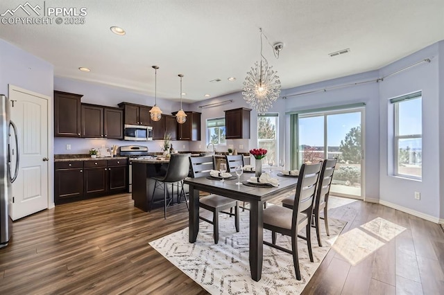 dining space featuring a chandelier, wood finished floors, and recessed lighting