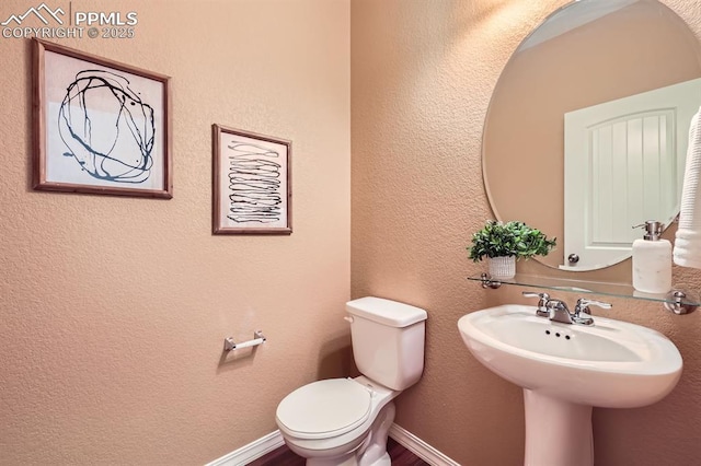 bathroom featuring toilet and baseboards