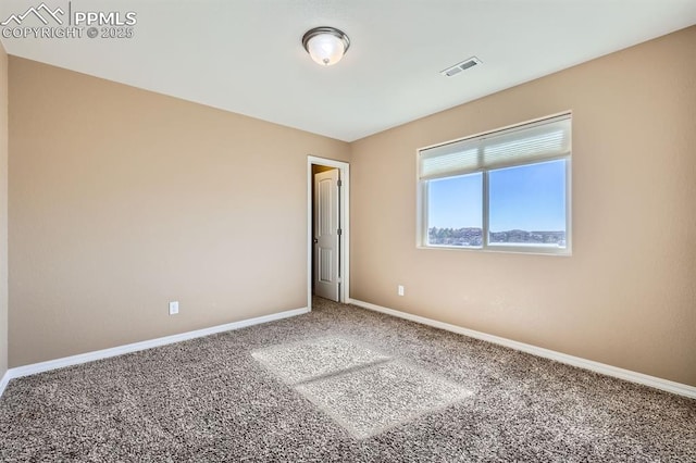 carpeted empty room featuring baseboards and visible vents