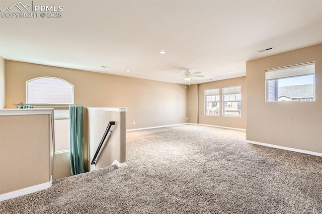 unfurnished room featuring carpet floors, baseboards, visible vents, and a ceiling fan