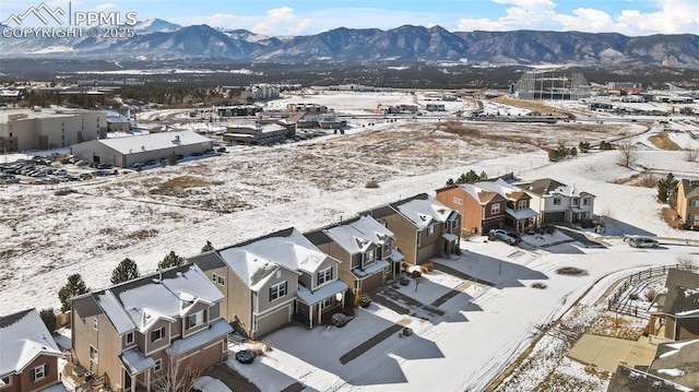 snowy aerial view featuring a residential view and a mountain view