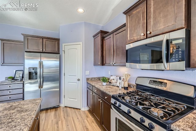 kitchen featuring stainless steel appliances, light stone counters, light wood-type flooring, and dark brown cabinetry