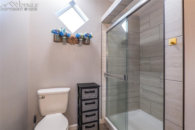 bathroom with a shower stall and toilet