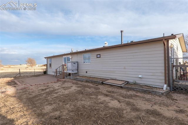 rear view of house with a patio area and fence