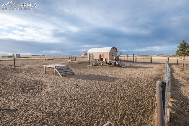 view of yard with fence and a rural view