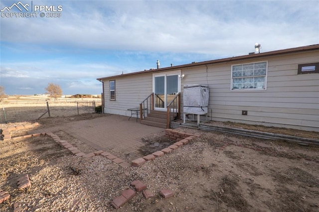 back of house with entry steps, a patio area, and fence