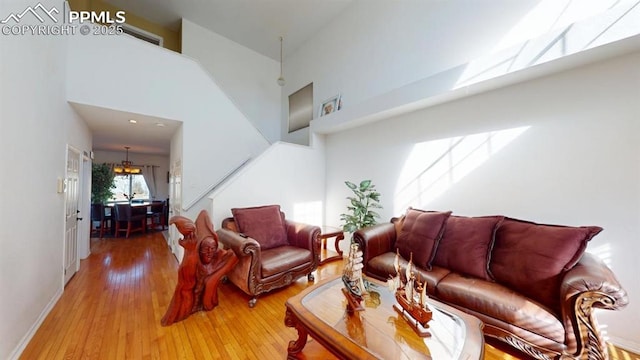 living room featuring light wood-type flooring and a high ceiling