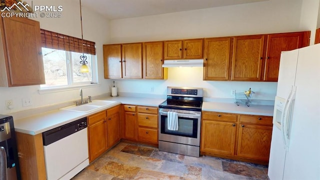 kitchen with white appliances, under cabinet range hood, brown cabinetry, and a sink