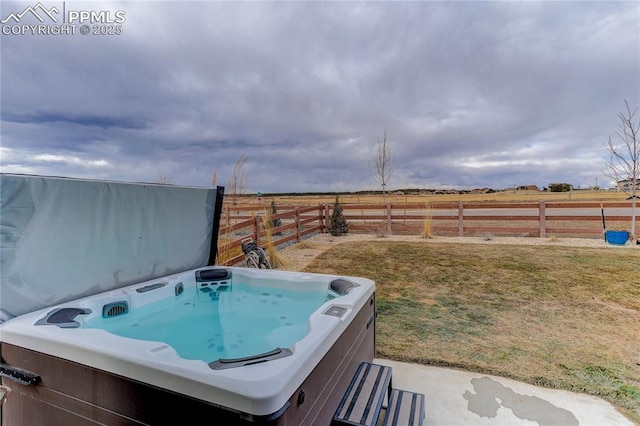 view of yard featuring a rural view, fence, and a hot tub