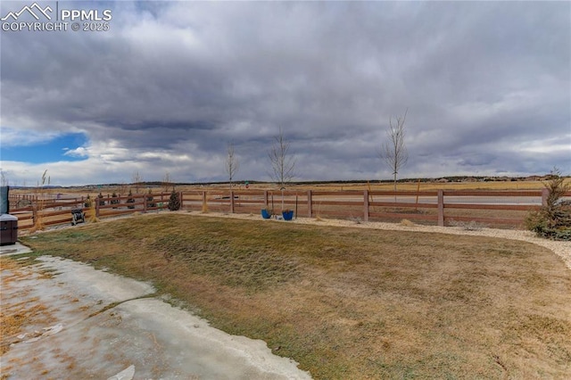 view of yard featuring a rural view and fence