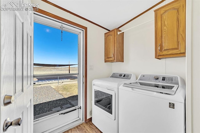 laundry room featuring separate washer and dryer, light wood-type flooring, and cabinet space