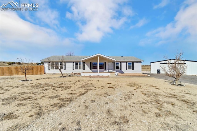 back of property with covered porch, fence, a detached garage, and an outdoor structure