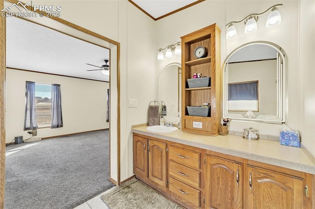 bathroom with ornamental molding, vanity, a textured ceiling, and a ceiling fan