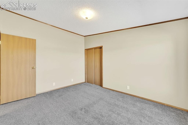 spare room with carpet floors, ornamental molding, a textured ceiling, and lofted ceiling