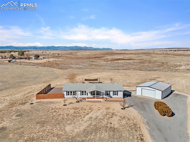 birds eye view of property featuring a rural view, a mountain view, and view of desert