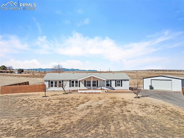 back of property featuring a garage, fence, and an outdoor structure