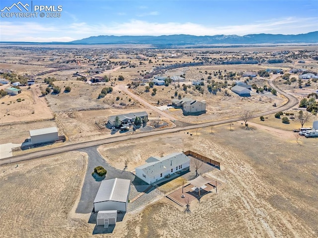 birds eye view of property featuring view of desert and a mountain view