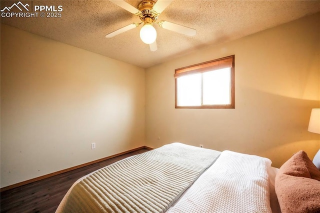 bedroom with ceiling fan, a textured ceiling, baseboards, and wood finished floors