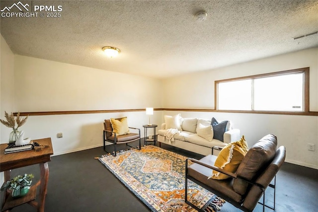 living room featuring baseboards, visible vents, and a textured ceiling