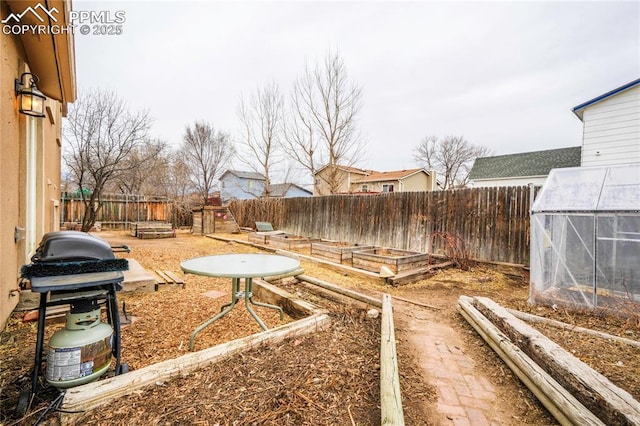 view of yard featuring an outdoor structure, a vegetable garden, a fenced backyard, and an exterior structure