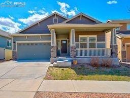 1425 Grand Overlook St, Colorado Springs, CO 80910 - craftsman-style home with covered porch, a garage, and concrete driveway