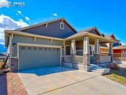 1425 Grand Overlook St, Colorado Springs, CO 80910 - view of front of house with covered porch, a garage, and concrete driveway
