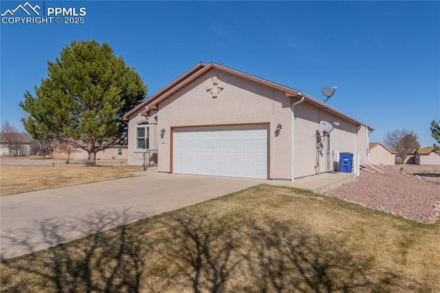 view of front of house featuring a front yard, concrete driveway, an attached garage, and stucco siding