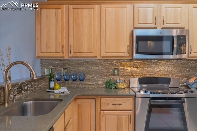 kitchen with stainless steel appliances, light brown cabinetry, a sink, and decorative backsplash