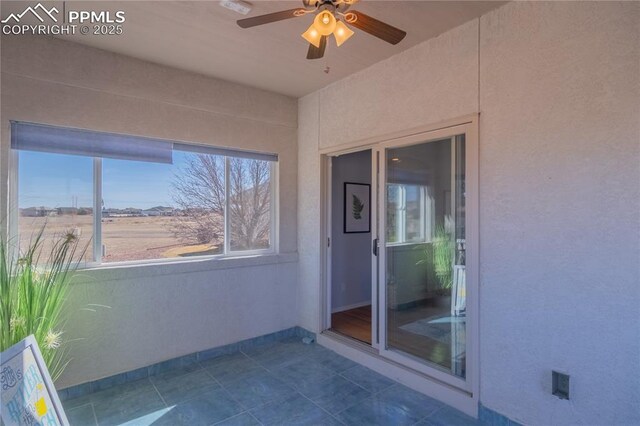 unfurnished sunroom with ceiling fan